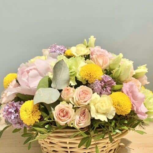 Panier Printanier – composition florale pastel avec fleurs fraîches et panier en osier